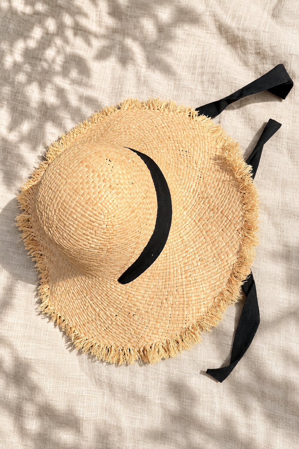 Woven straw sun hat resting on a linen surface