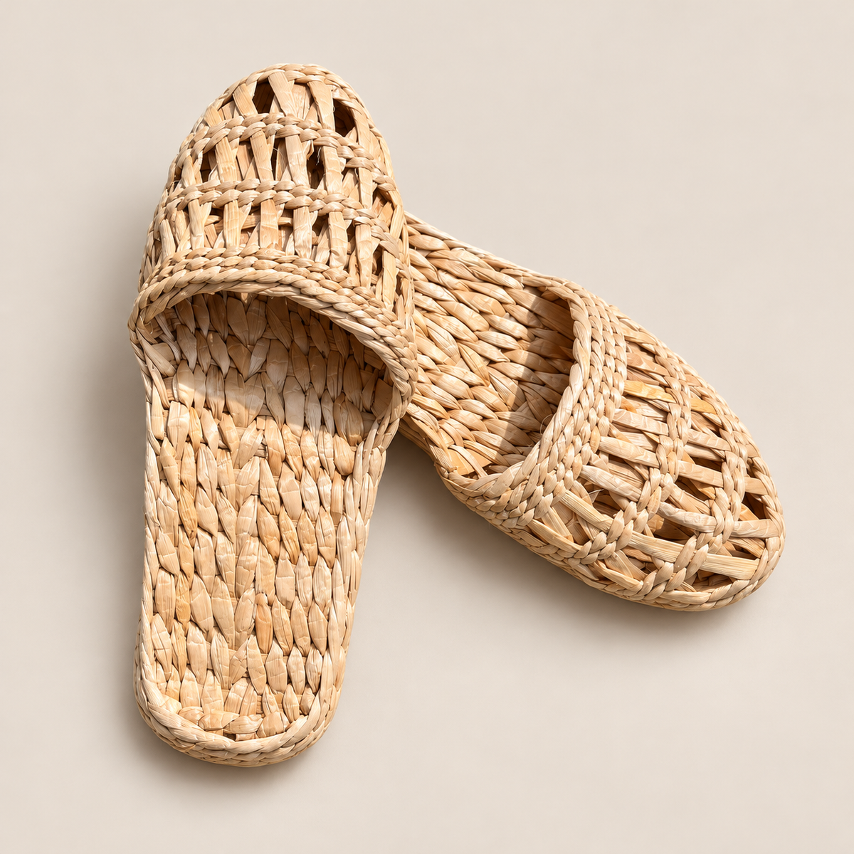 Handmade Woven Straw Slippers: Eco-Friendly House Shoes for Women on a beige backdrop