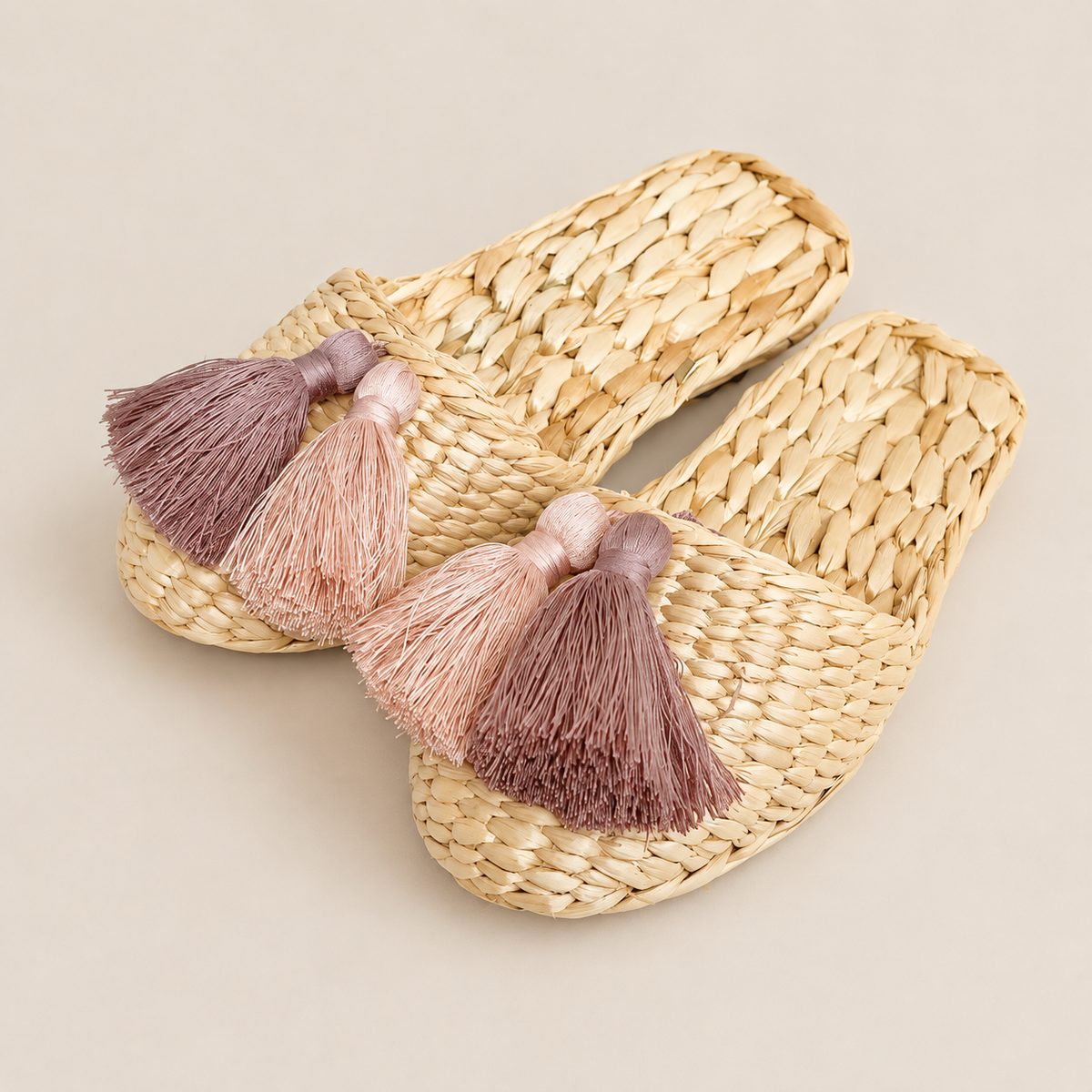 Handmade Cattail Slippers with Tassels, Closed Toe Straw House Shoes for Women on a beige backdrop