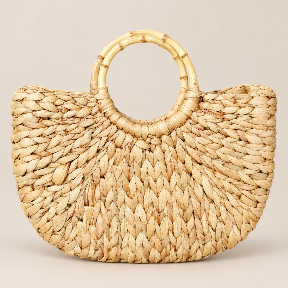 Handwoven Straw Tote: Natural Boho Beach Bag with Bamboo Handles on a beige backdrop