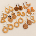 Handmade Rattan Earrings, Lightweight Woven Boho Statement Earrings, Tropical Hoop and Drop Earrings for Women on a beige backdrop