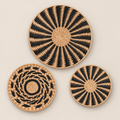 Woven Wall Basket Set of 3, Handmade Cattail Boho Wall Art, Black and Natural Round Wall Decor for Living Room on a beige backdrop