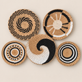 Woven Wall Basket Set of 5, Handmade Cattail Boho Wall Art in Black White and Natural, Round Wall Decor for Bedroom on a beige backdrop