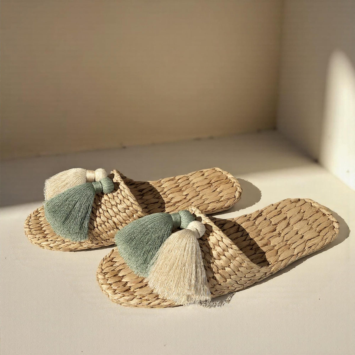 Pair of handmade straw slippers with closed toe and wide woven upper, decorated with three large tassels in white, mint green, and cream. Natural beige color, lightweight and breathable. - view 2