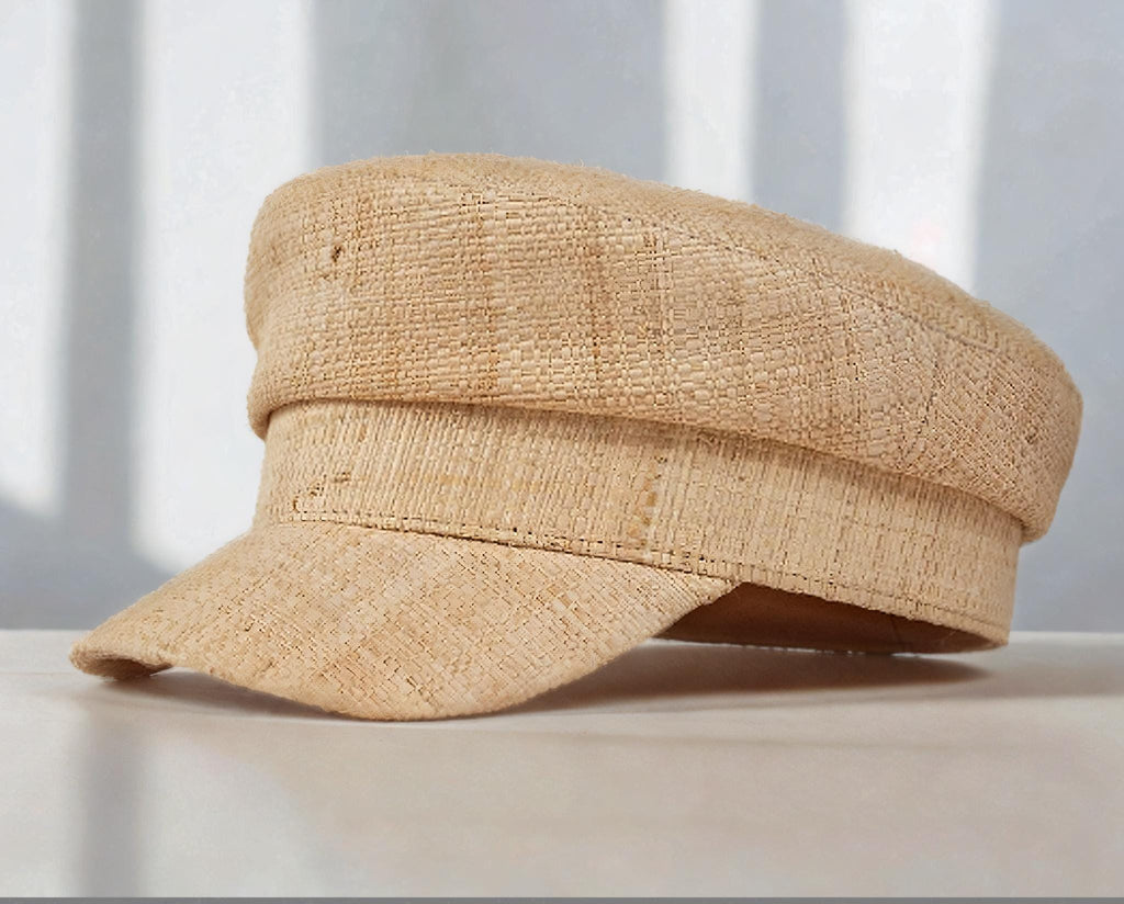 Natural straw sun hat in a flat cap style with a short curved brim, displayed indoors with soft light. Lightweight, stylish summer hat for beach, outdoor UV protection, vacation, garden, honeymoon, or as a thoughtful gift for her mom.