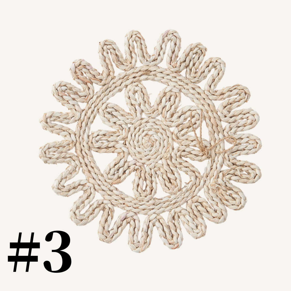 A decorative woven mat or placemat with a circular design resembling a sunflower or flower pattern.