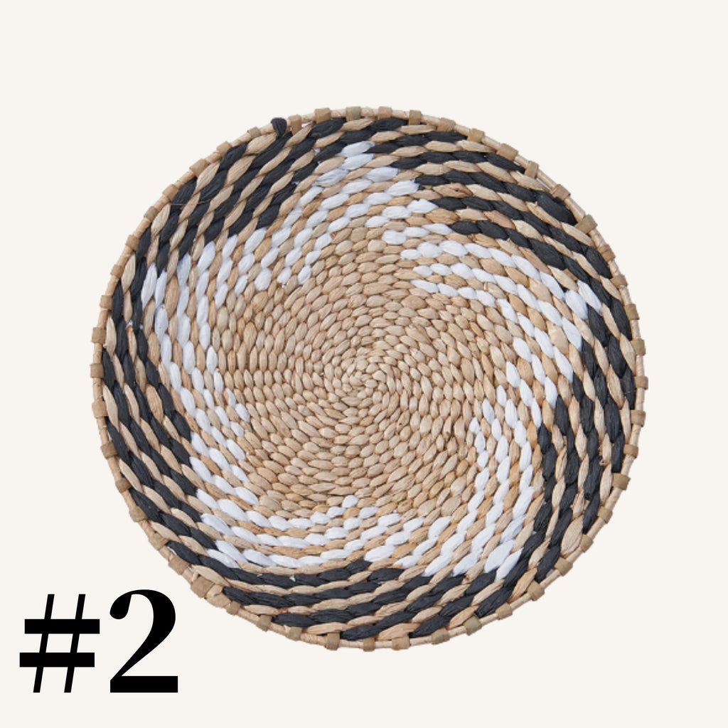 A woven basket with a spiral pattern in black, white, and beige colors.