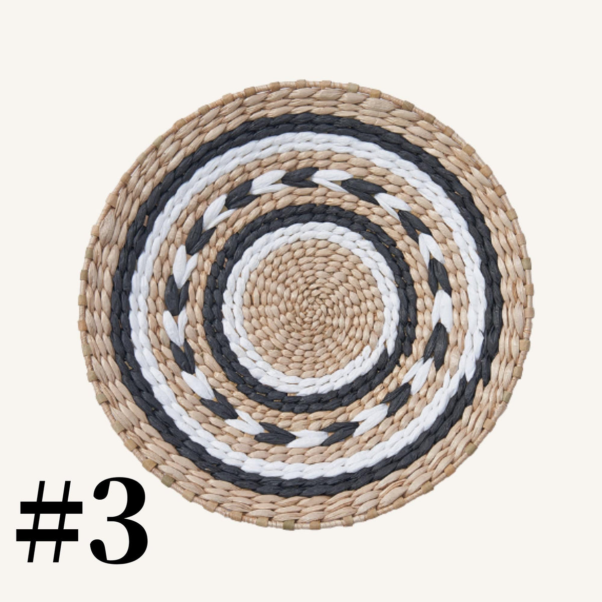 A woven placemat with a circular pattern of alternating black and white stripes.