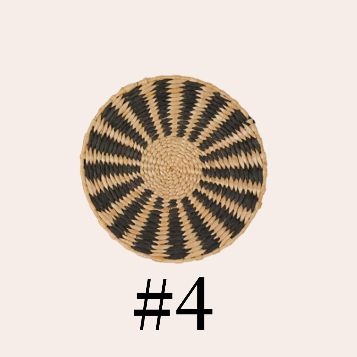 a round woven dish with a black and white striped pattern.