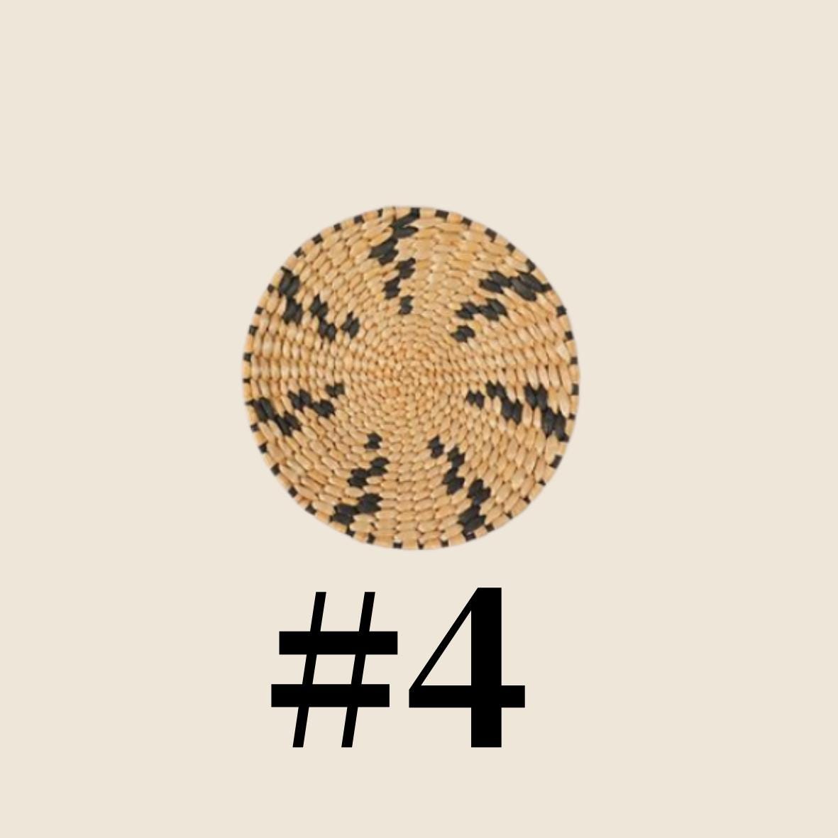 a round woven basket with a distinctive black and white pattern.