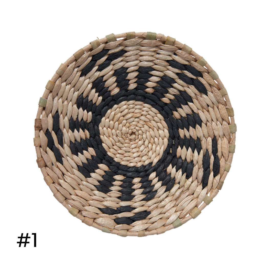 a woven basket with a black and white pattern, featuring a circular design in the center.