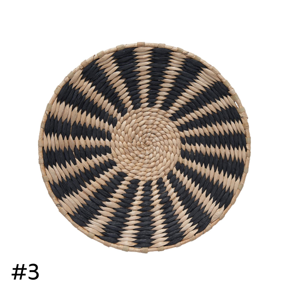 A round woven basket with a black and white striped pattern.