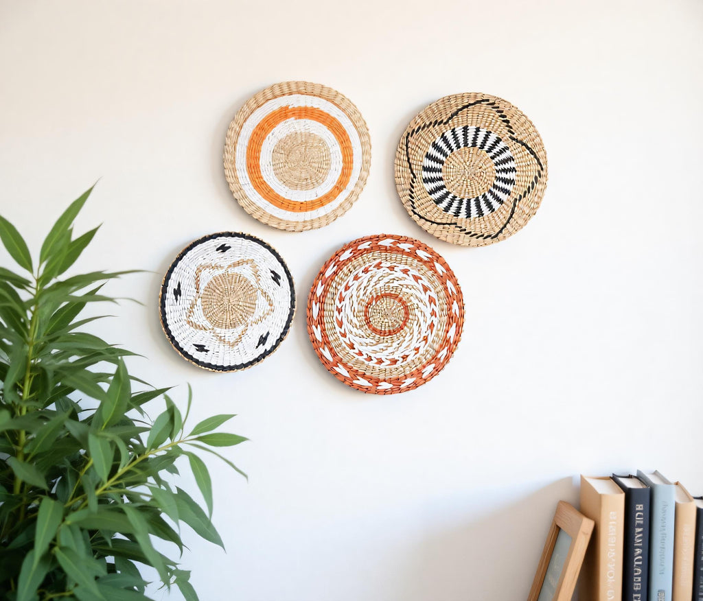 four decorative woven plates or baskets hanging on a white wall, with a potted plant to the left side.