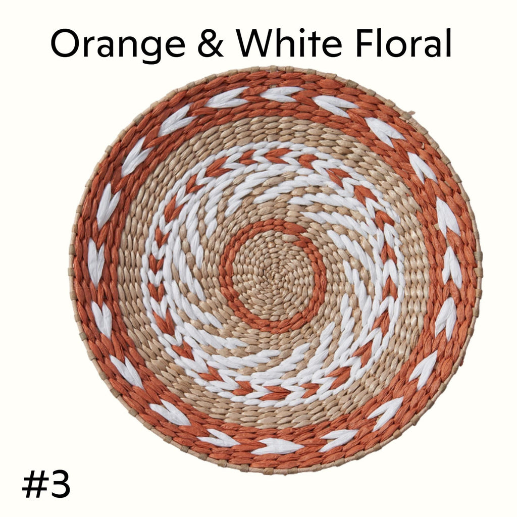 a round woven basket with a spiral pattern in shades of orange and white.