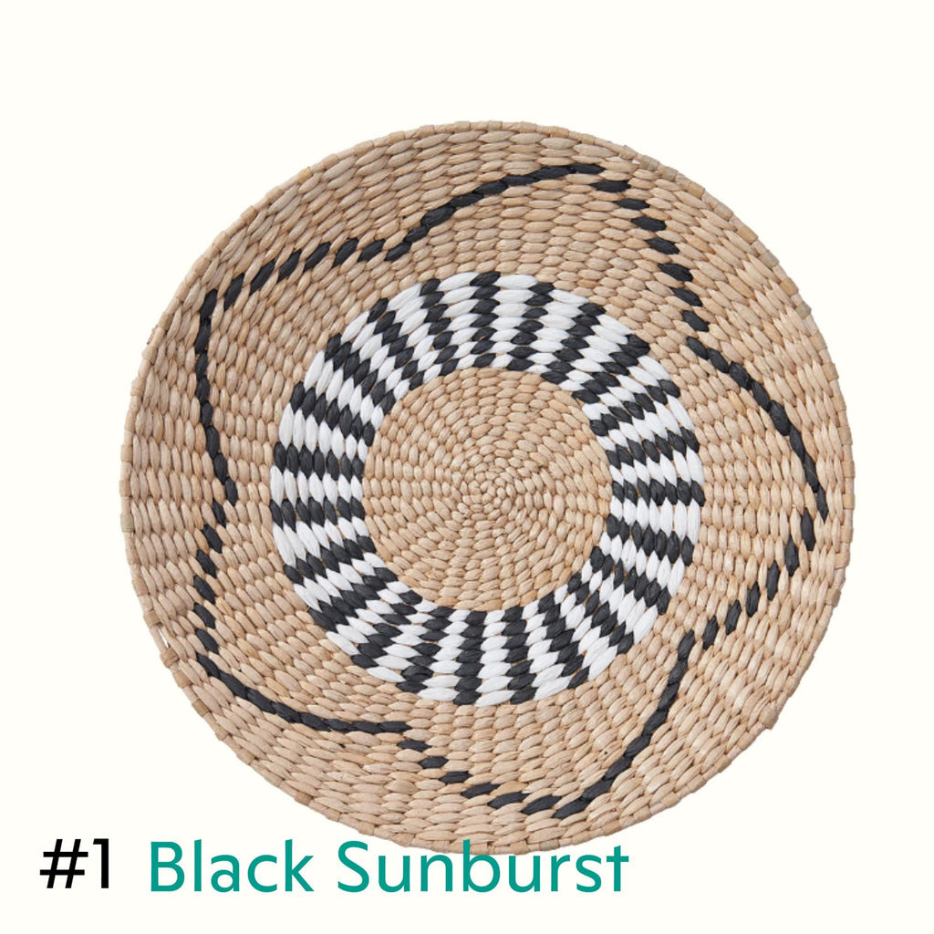 a round woven basket with a black and white striped pattern around the edge.