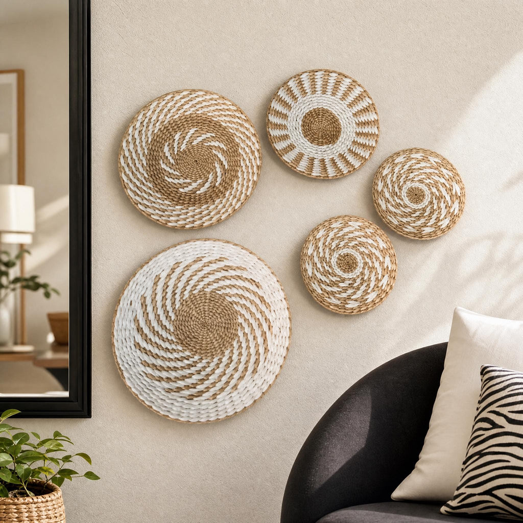 a living room with a black sofa and a mirror on the wall. There are four woven baskets with a spiral pattern, which are displayed on the wall as wall art.