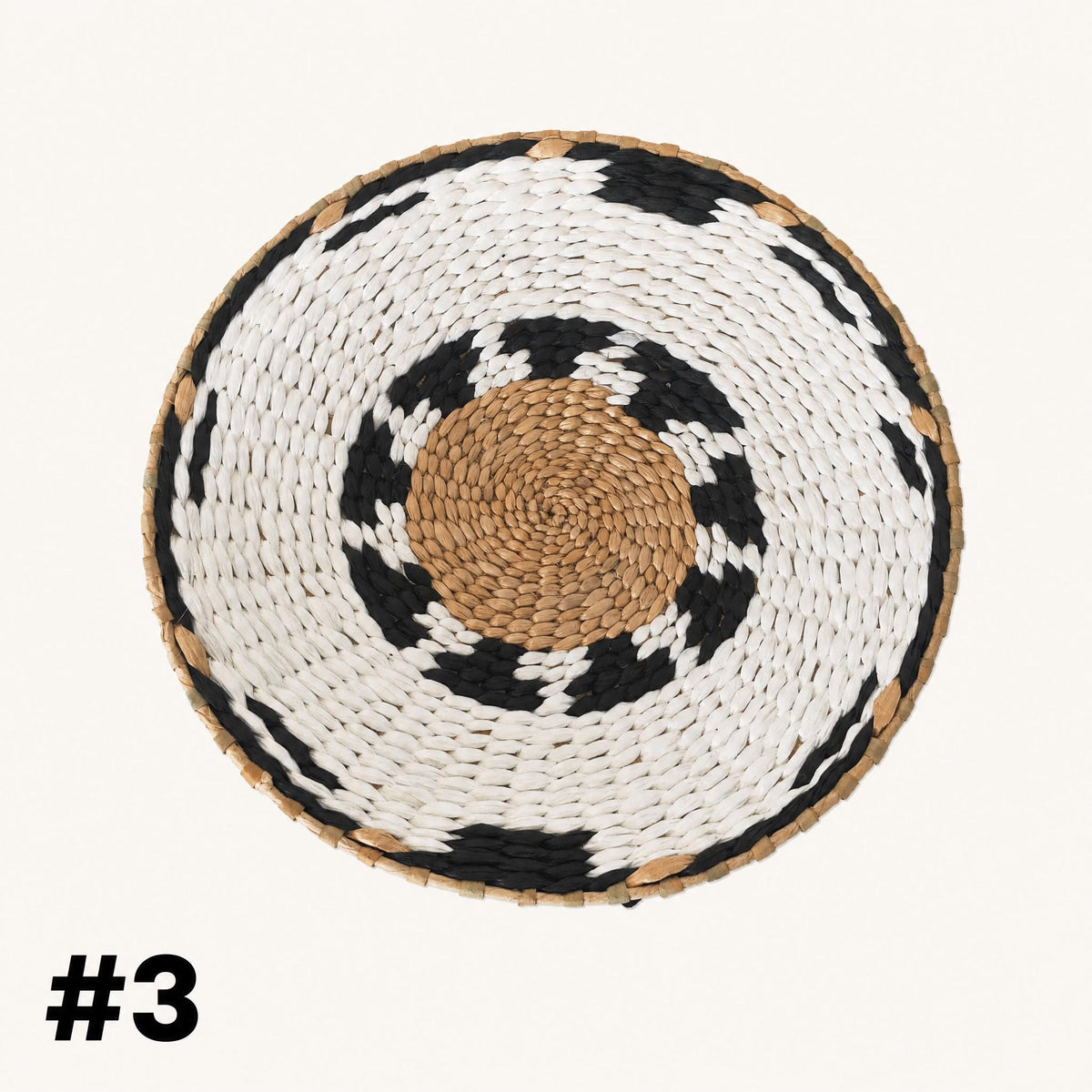 A woven basket with a circular pattern of white and black colors, featuring a central brown circle.