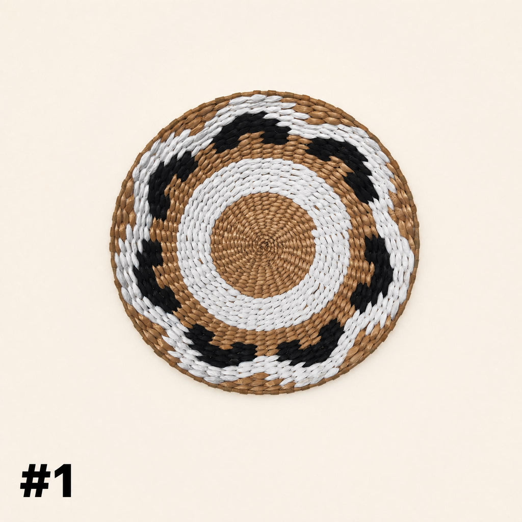 A woven mat with a circular pattern of brown, white, and black colors.