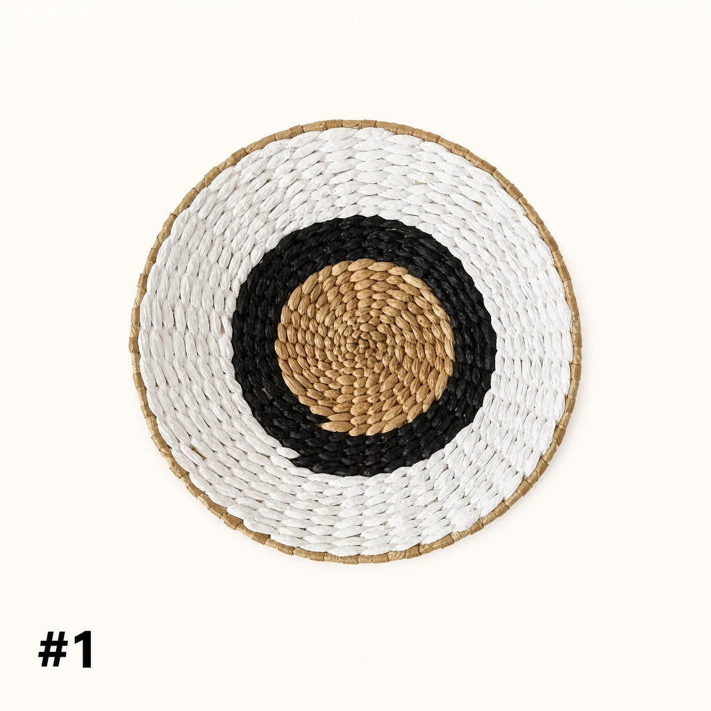 A woven basket with a black and white circular design in the center, placed against a white background.