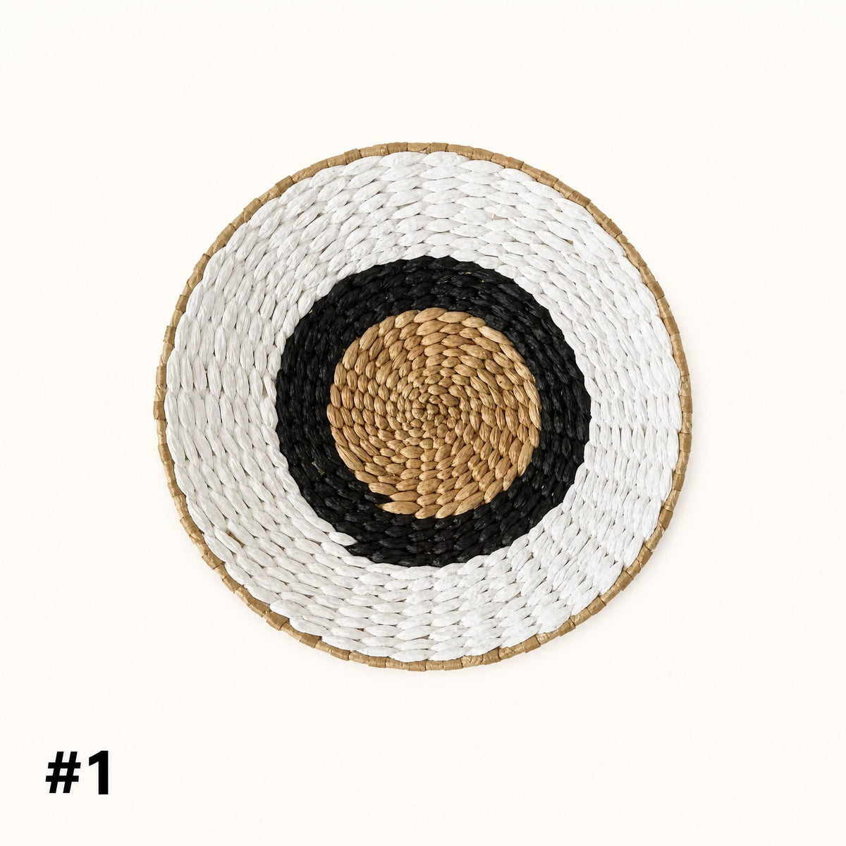 A woven basket with a black and white circular design in the center, placed against a white background.