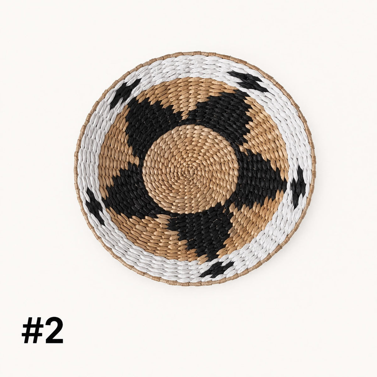 A woven basket with a circular pattern of black and brown colors, featuring a white border.