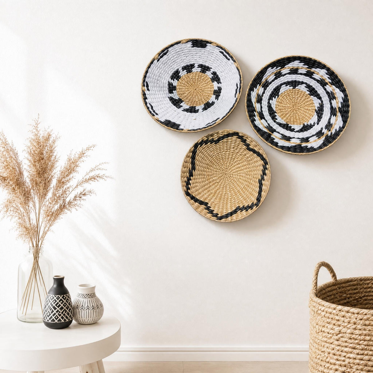 a minimalist interior design with a white wall, three woven baskets, and a small table with decorative items.