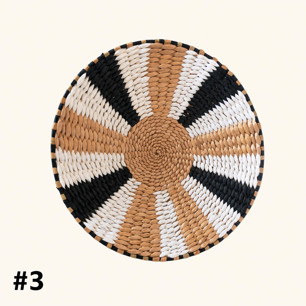 A woven basket with a circular pattern of alternating black and white stripes.