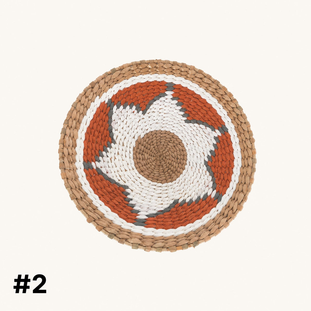 a round woven mat with a circular design in shades of orange and white.