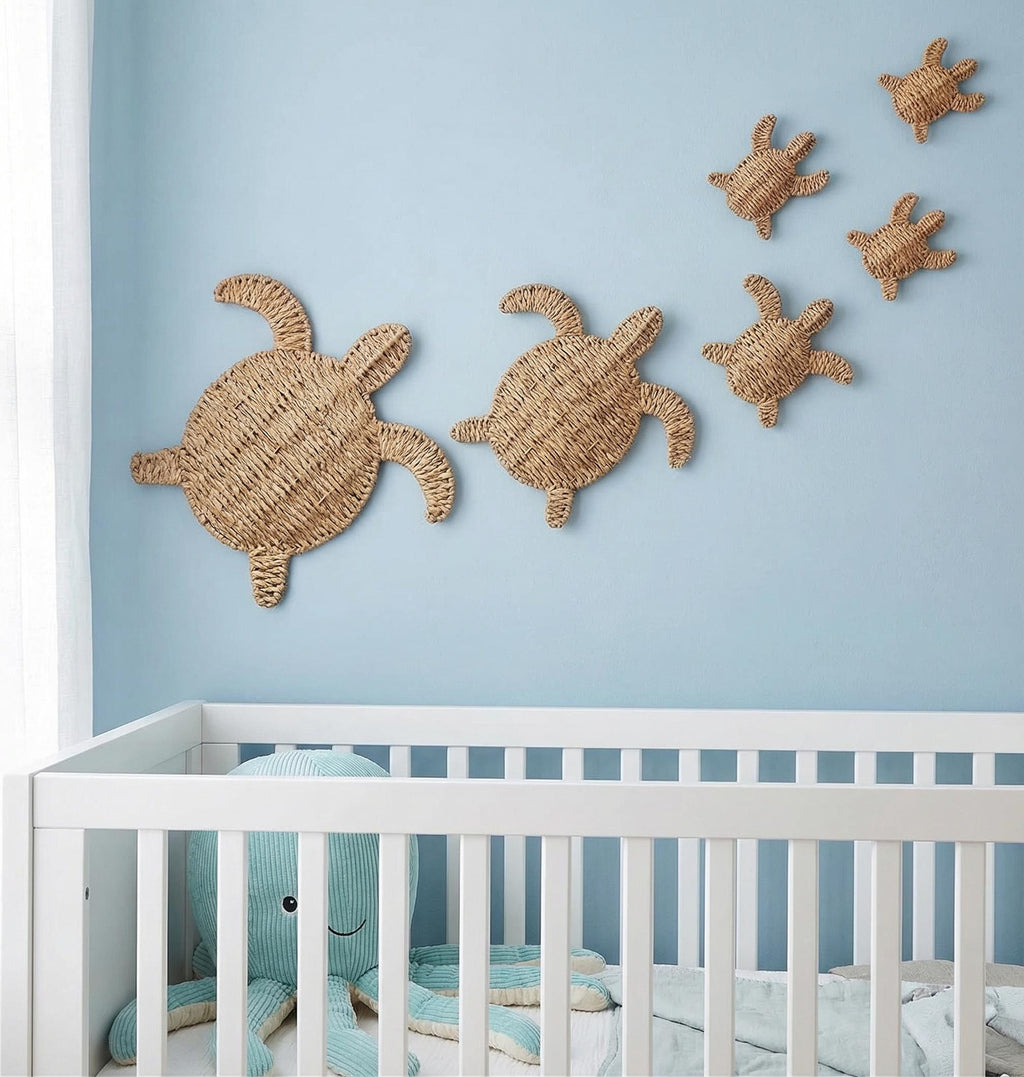 A nursery room with a white crib and a blue stuffed animal. Above the crib, there are three woven turtle-shaped wall decorations.
