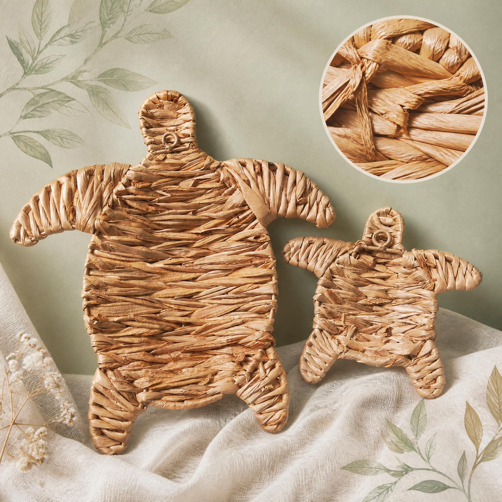 two woven turtle-shaped objects made from a natural material, placed on a fabric surface.