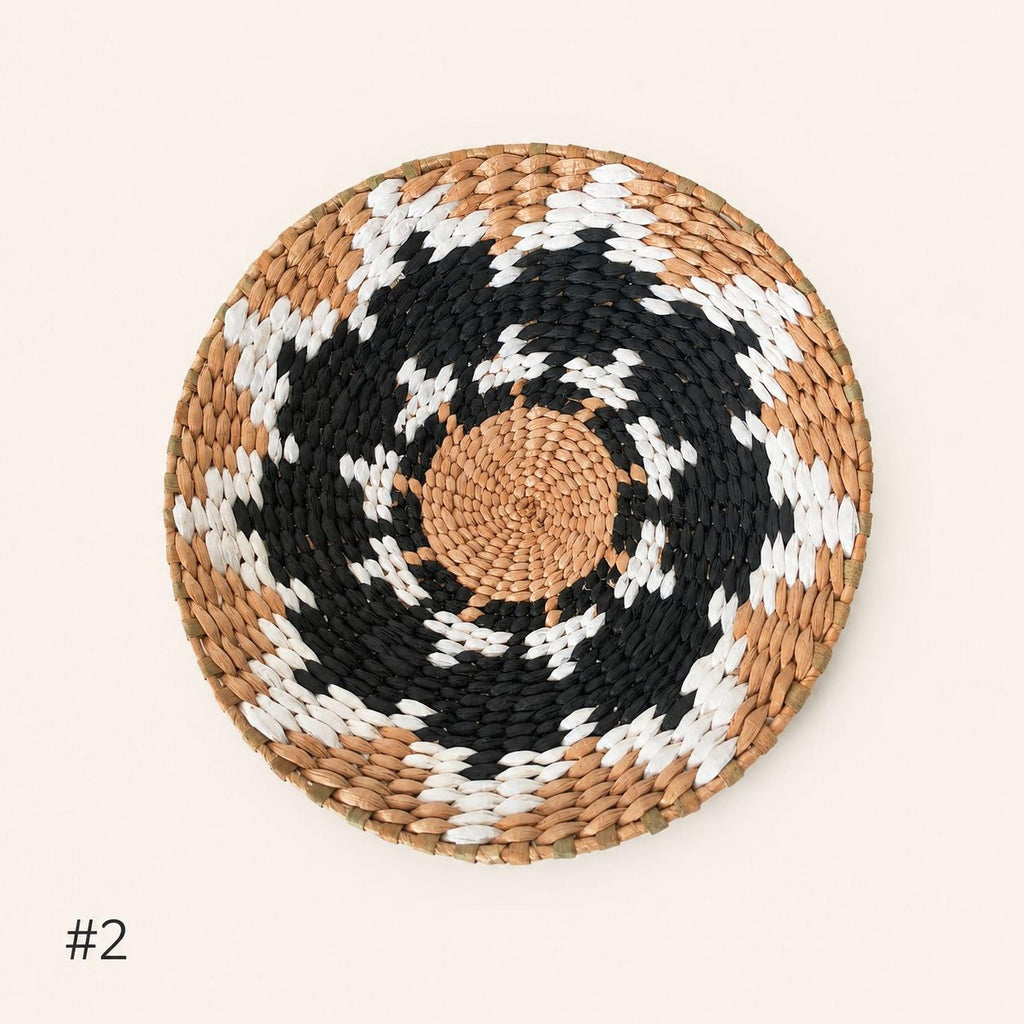 A woven basket with a circular pattern of alternating black and white colors.