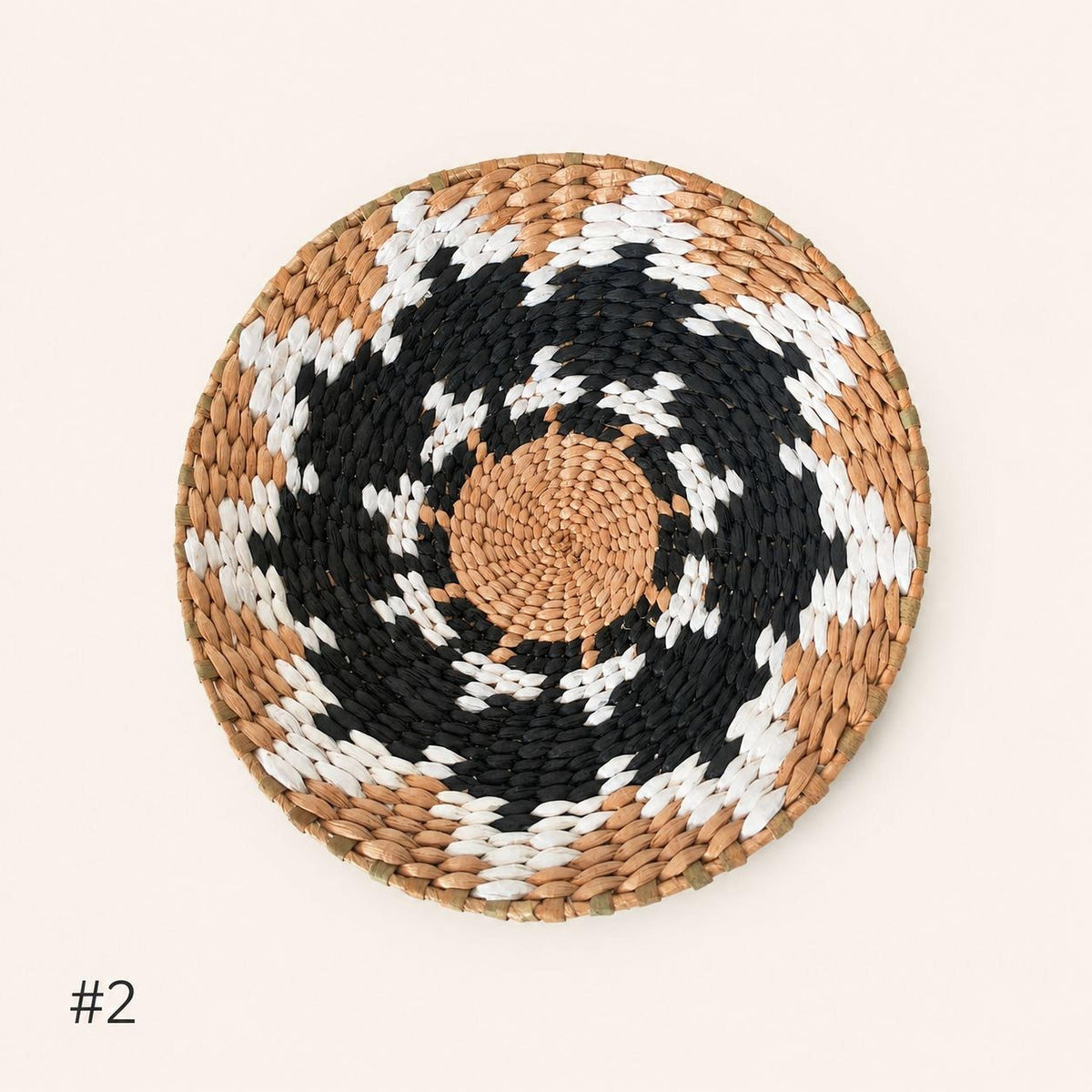 A woven basket with a circular pattern of alternating black and white colors.