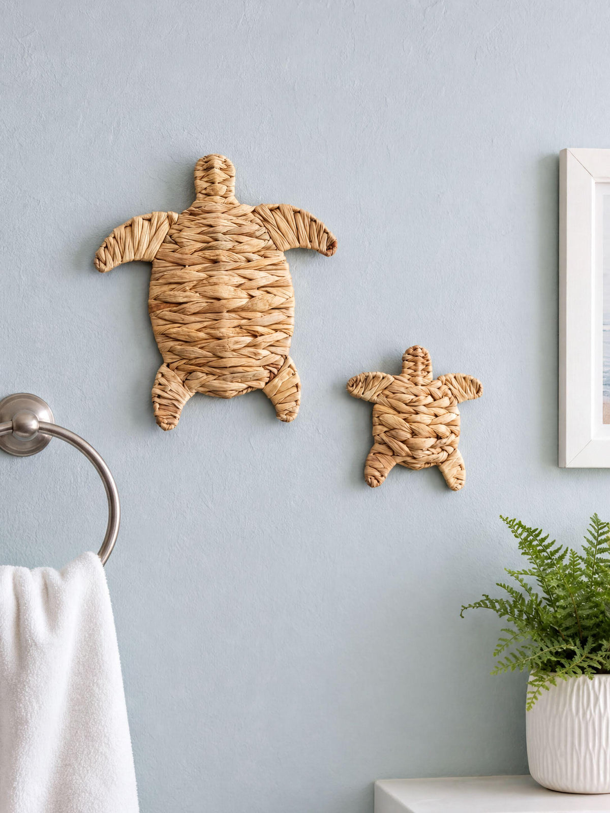 two woven turtle-shaped wall decorations hanging on a light blue wall.