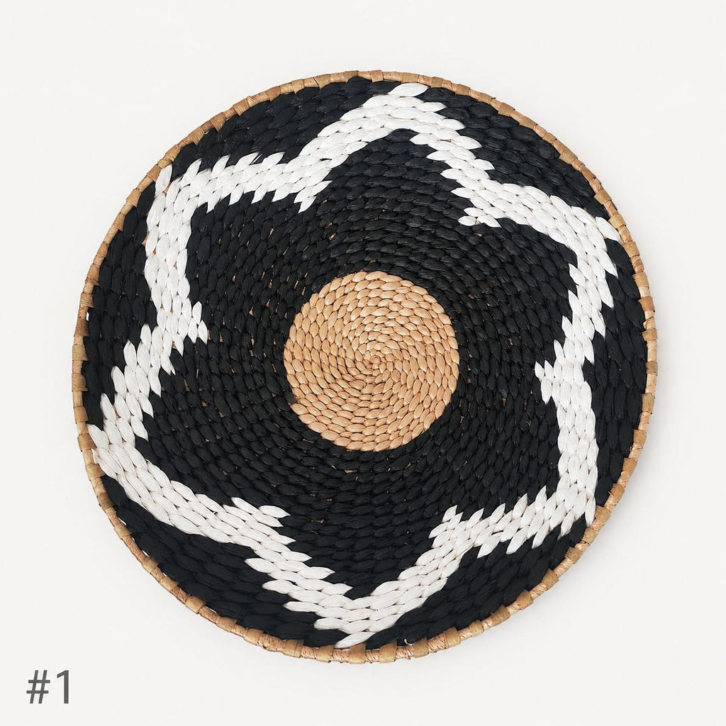 A woven basket with a black and white star pattern and a brown circular center.