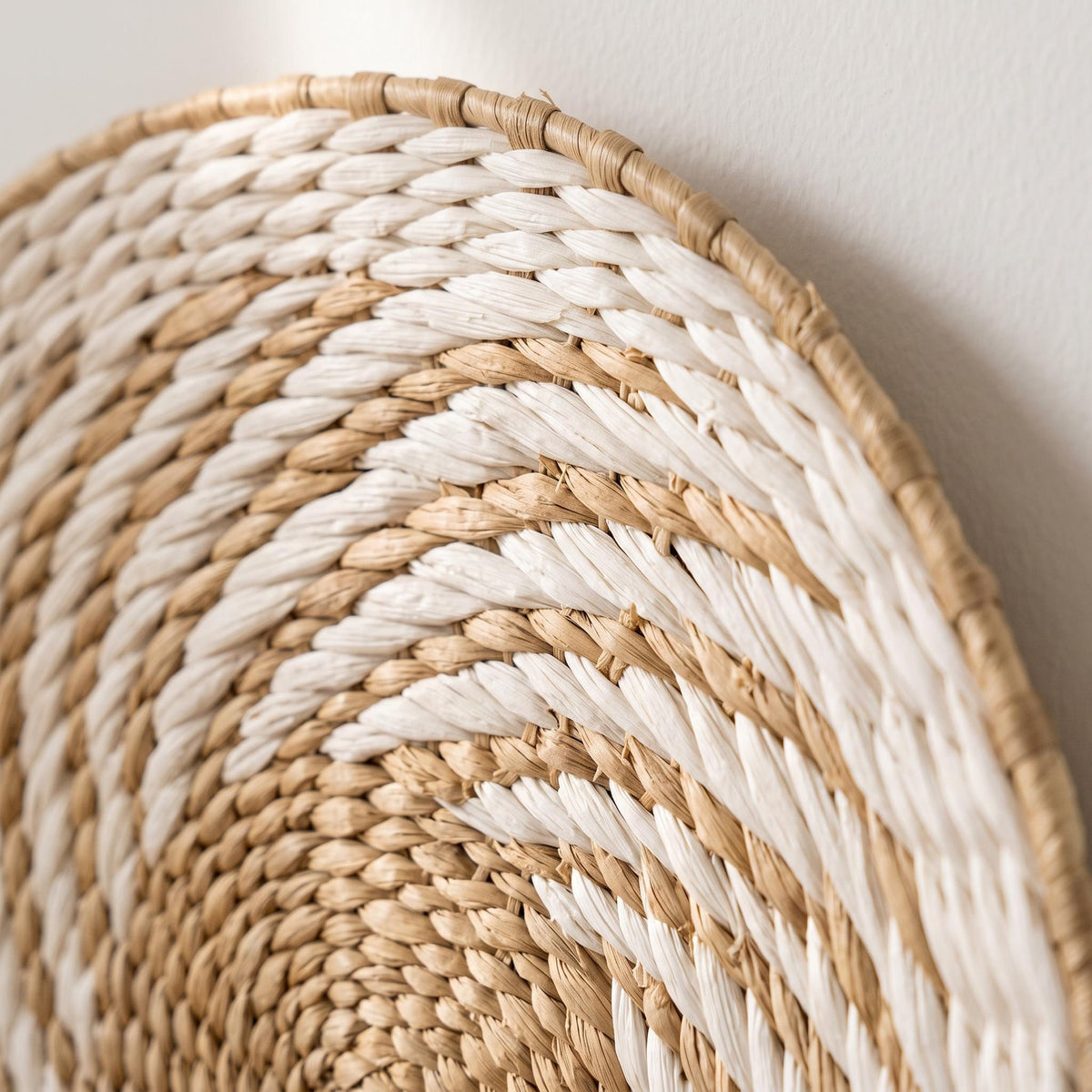 Close-up of the woven water hyacinth wall basket showing natural and white fiber coils