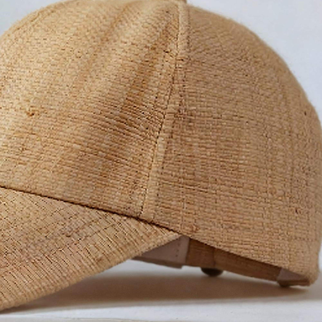 Close-up of the handwoven raffia straw texture and stitched panel seams of the baseball cap