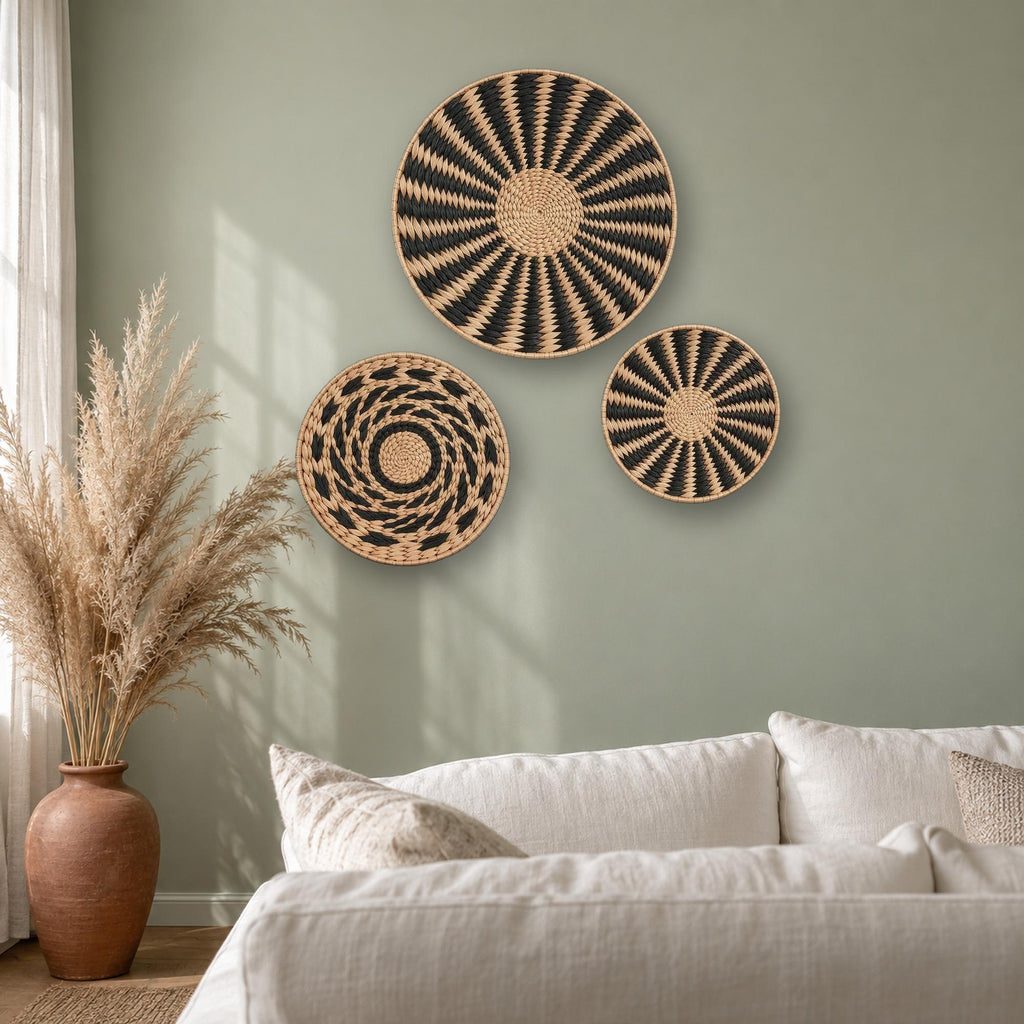 Three round woven cattail wall baskets as boho living room wall decor on a sage green wall with pampas grass
